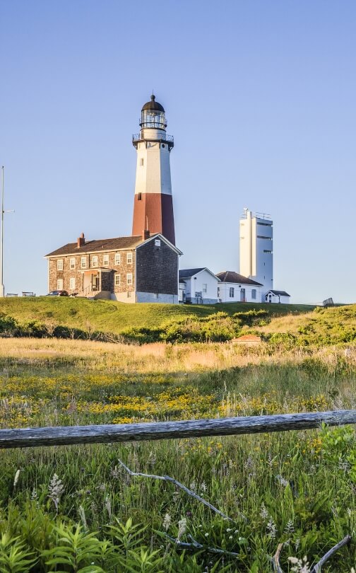 photo of a lighthouse overlooking a meadow